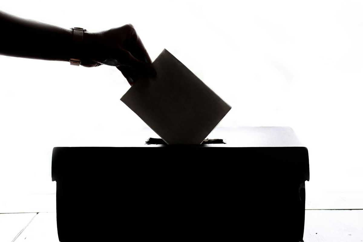 Einwurf eines Wahlscheins in eine Wahlurne Einwurf eines Wahlscheins in eine Wahlurne