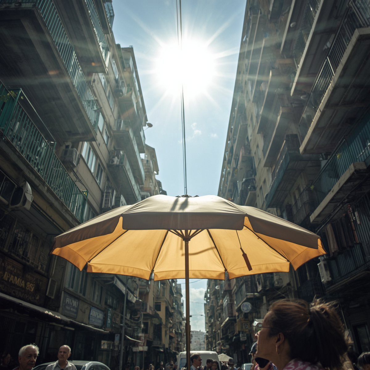 Ein gelber Sonnenschirm in einer Straßenenge unter praller Sonne