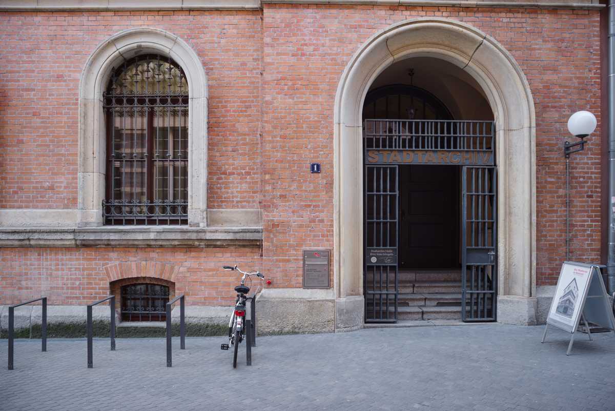 Haupteingang des Stadtarchivs mit Torbogen an einem roten Backsteingebäude